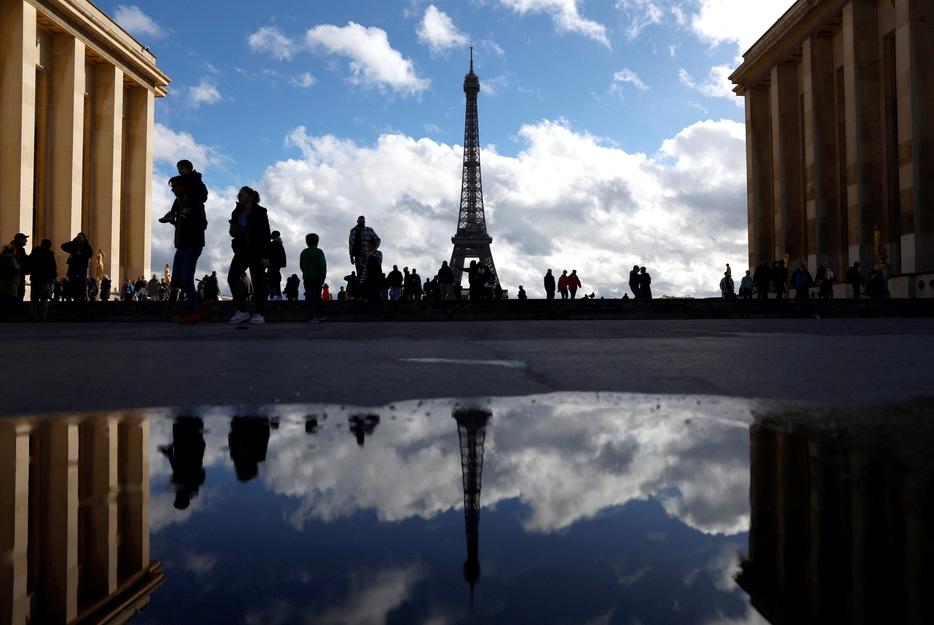 　過去数十年間にわたり欧州連合（ＥＵ）をけん引してきた２大経済国フランスとドイツで政局危機が起こり、欧州経済は低迷から抜け出す活性化の取り組みが後退しつつある。写真は、エッフェル塔を眺める人々。２０２３年１０月、パリで撮影（２０２４年　ロイター/PETER CZIBORRA）