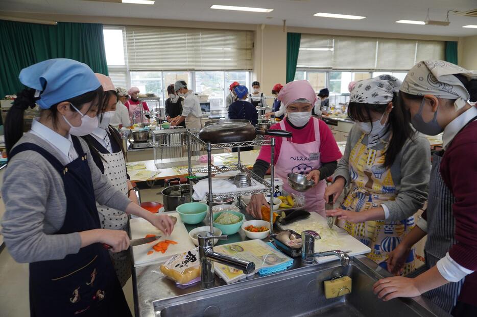 栄養委員に教わり、クッキングに挑戦する生徒たち=岡山県津山市で