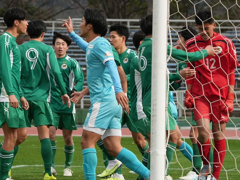 PKストップしたGK野村寛礼(写真右)を称える大阪体育大の選手たち(Tatsuya TAKEUCHI/GEKISAKA)