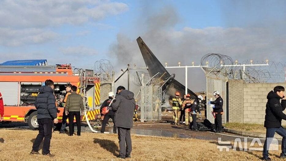 務安国際空港の墜落現場で救助作業を進める消防当局者(c)NEWSIS