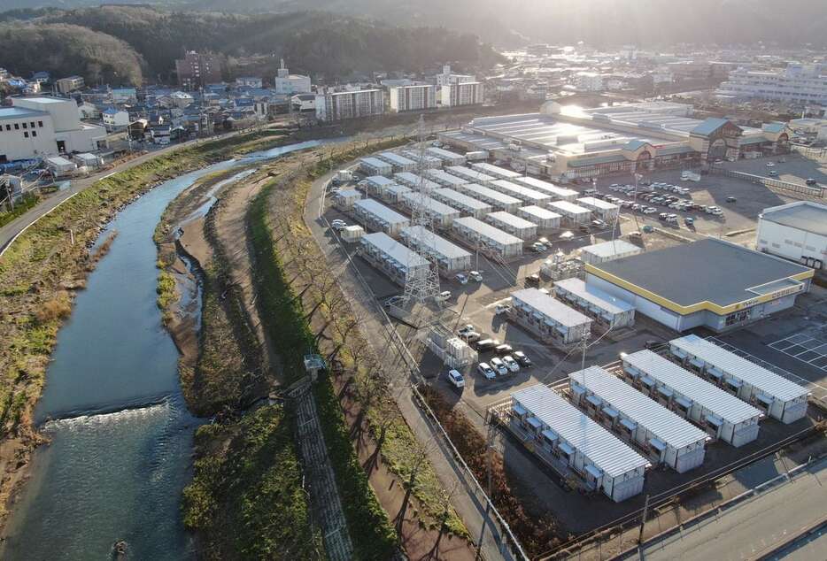 ９月の記録的豪雨で浸水した仮設住宅の「宅田町第2団地」（右）。河原田川が間近を流れる＝30日午前、石川県輪島市（ドローン使用、恵守乾撮影）