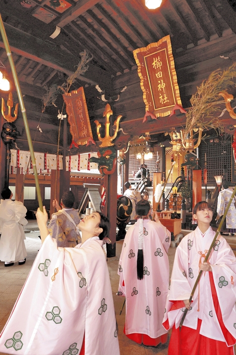 たまったほこりを払い落とす巫女ら（21日午前、福岡市博多区の櫛田神社で）＝長野浩一撮影