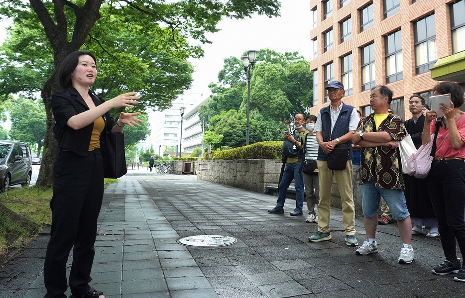 ウィシュマさんの遺族による裁判が行われている名古屋地裁前で、傍聴者らに裁判の経過などを説明する本間鮎美さん＝2024年7月、筆者撮影