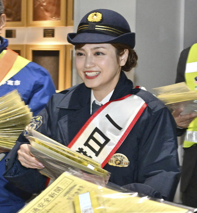 一日警察署長を務め、駅利用者にチラシを手渡す平さん