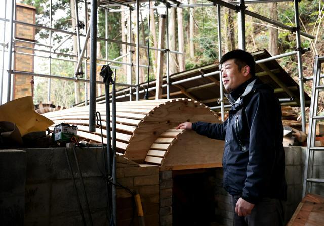 穴窯の修復に取り組む清水武徳さん。型枠をはめた状態で冬を越し、れんがは春になってから組み上げる=石川県珠洲市、林敏行撮影