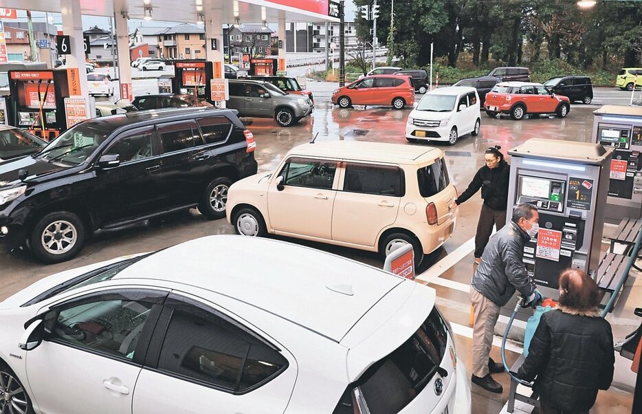 ガソリンや灯油を買い求める人や車で混み合うスタンド＝１８日午後４時ごろ、富山市内