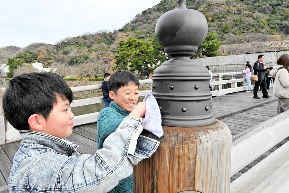 擬宝珠を雑巾で丁寧に拭く児童ら＝１６日、鳥取市東町２丁目の擬宝珠橋