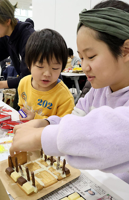 クッキーやチョコレートを組み合わせてお菓子の家を作る子どもたち＝山形市・道の駅やまがた蔵王