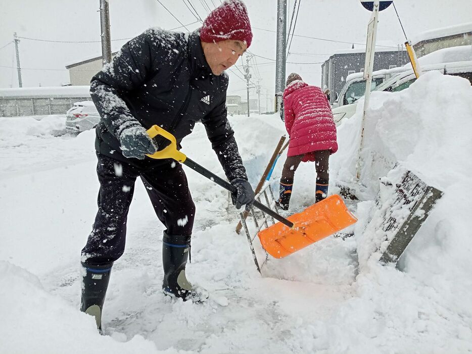 除雪に追われる弘前市民＝23日午後3時ごろ、弘前市田茂木町