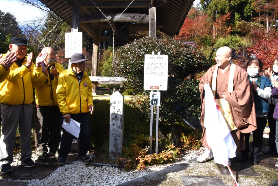 除幕をして新たな看板の設置を祝う参加者=岡山県津山市で