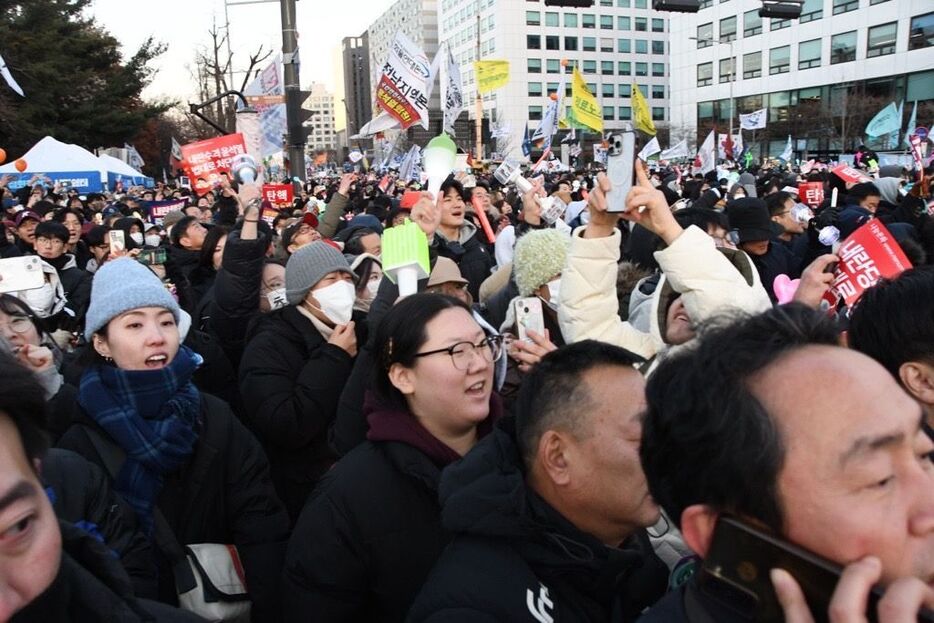 弾劾訴追案採決の票数が読み上げられ、可決されたことを喜ぶ国会議事堂前の市民たち＝14日午後5時ごろ、韓国・ソウル