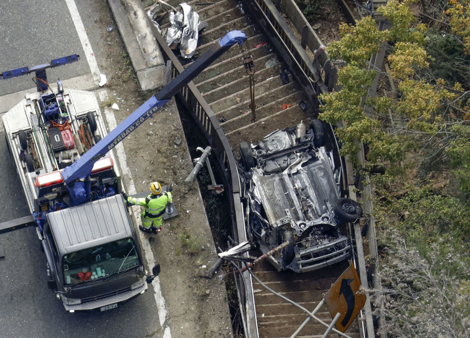 ダンプカーと衝突し、道路脇の階段に転落した乗用車＝11月、広島市（共同通信社ヘリから）