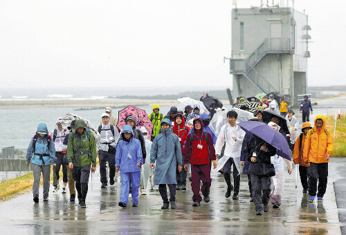 雨の中、ゴールを目指してコースを歩く参加者（６月２３日、宮城県名取市で）