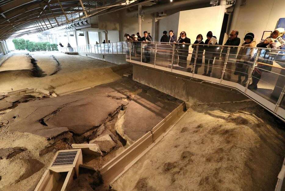 野島断層保存館を見学するシンポジウムの参加者ら＝7日午後、兵庫県淡路市の北淡震災記念公園（川村寧撮影）