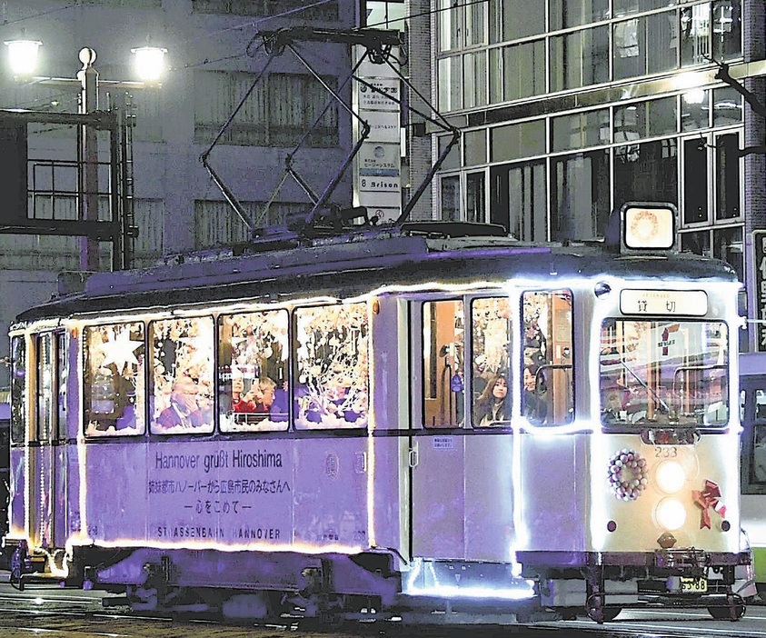 電飾をきらめかせて走り始めたクリスマス電車（広島市中区で）