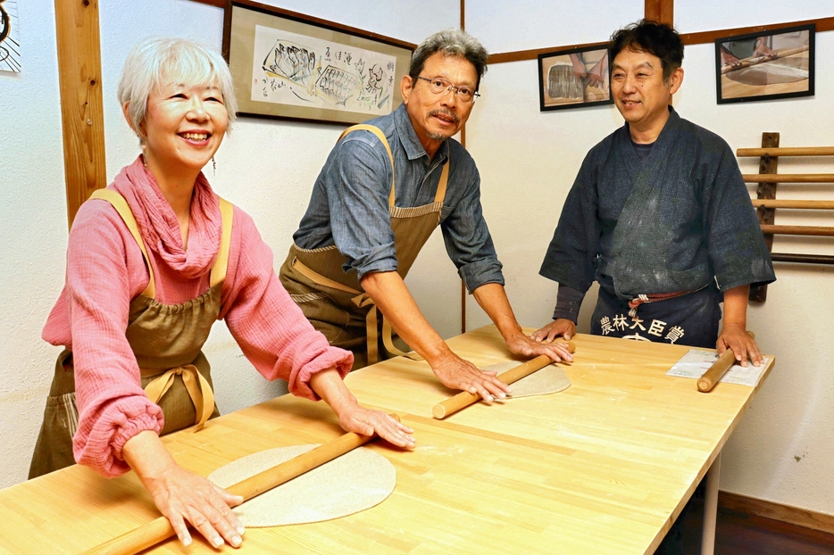 光武さん（右）から習いながらそば打ちに挑戦する中野さん夫婦