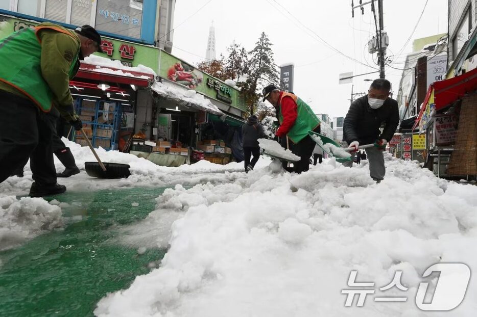 記録的な大雪が降る中、京畿道義王市の市場周辺で除雪作業する市民ら(c)news1