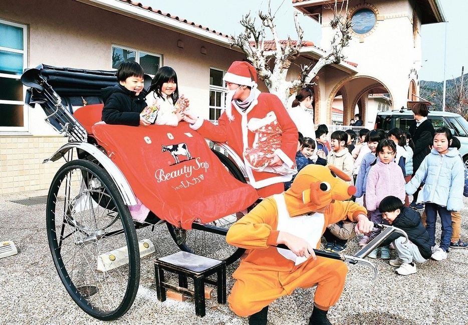 人力車に乗って、サンタクロースからプレゼントをもらう園児＝出雲市大社町杵築南、たいしゃ保育園