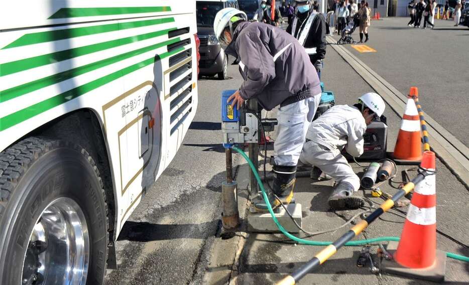 「富士山ローソン」での車道横断防止のために新たな策を設置する工事担当者ら＝16日、山梨県富士河口湖町（平尾孝撮影）