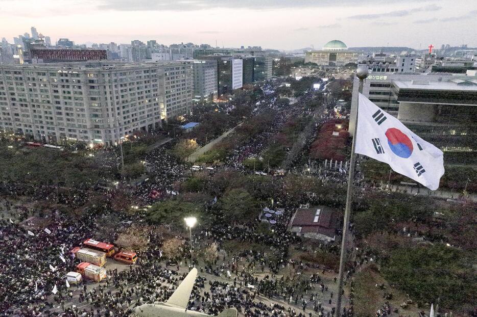 7日、韓国の尹錫悦大統領の弾劾などを求めてソウルの国会周辺に集まった市民ら（聯合＝共同）