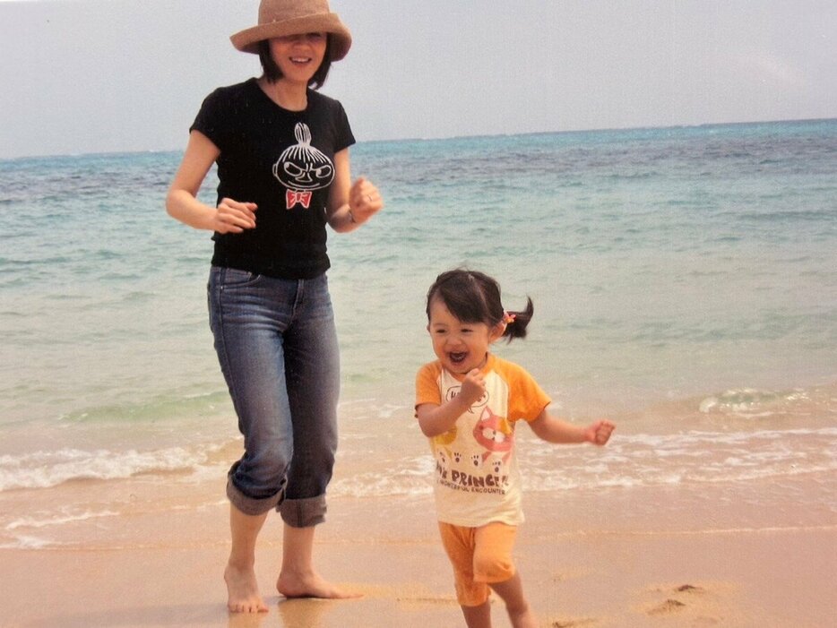 小さい頃の長女と海辺で遊ぶ武内陶子さん（本人提供）