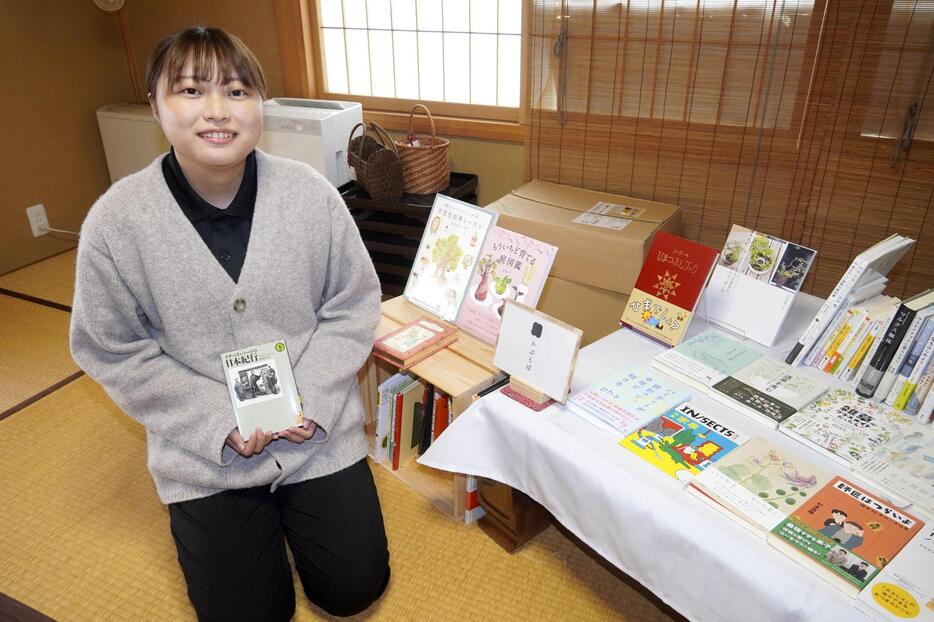 「かぷりば」で販売している本を手に取る川村佳恵さん＝山形県金山町