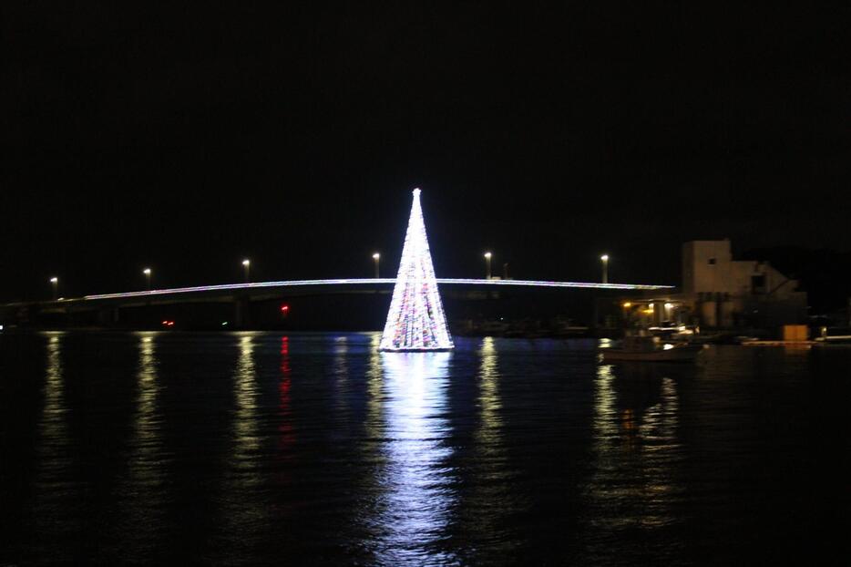 点灯したクリスマスツリー（前方）と本部大橋＝12月13日、本部町渡久地港海上イルミネーション