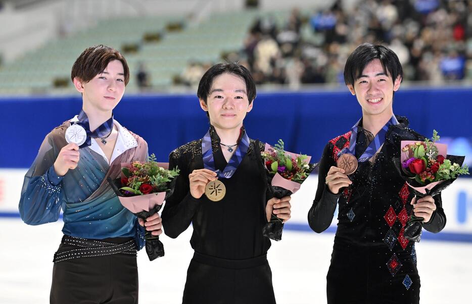 　表彰式で笑顔を見せる（左から）２位の中田璃士、初優勝の鍵山優真、３位の壷井達也（撮影・北村雅宏）