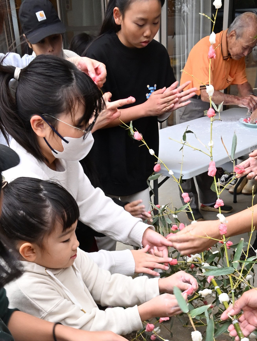 寒風の中で「しだれ餅」づくりに励む子どもたち＝28日、鹿児島県天城町松原