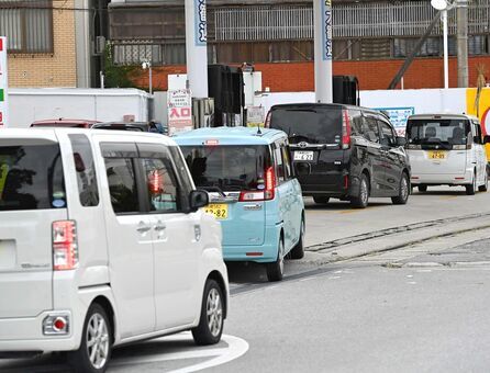 ガソリン代の値上がりに備え、駆け込み給油で車列ができる給油所＝１８日午後、那覇市内