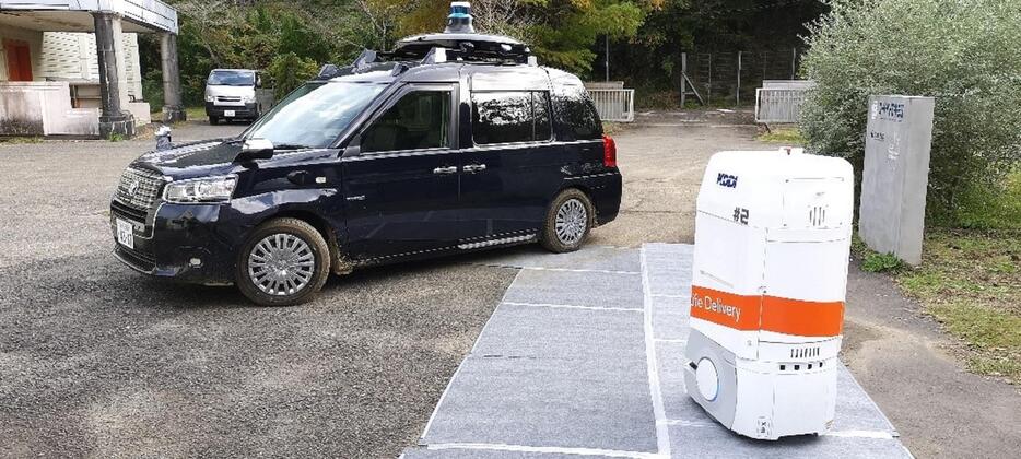 連携地点で自動配送ロボットから自動運転車へ荷物を受け渡した