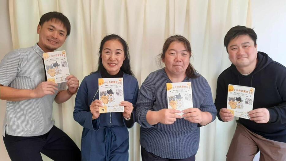 完成した冊子を手にする藤原さん、甲斐さん、山田さん、安孫子さん