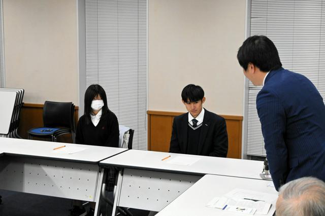 18歳成人式の実行委員の2人に謝罪する稲森稔尚市長（右）=2024年12月10日、三重県伊賀市上野丸之内、小西孝司撮影