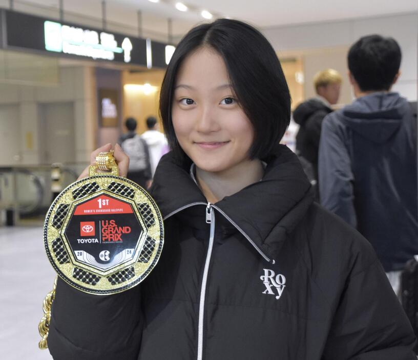 スノーボード・ハーフパイプのW杯初優勝を果たし、メダルを手に撮影に応じる清水さら＝24日午後、成田空港