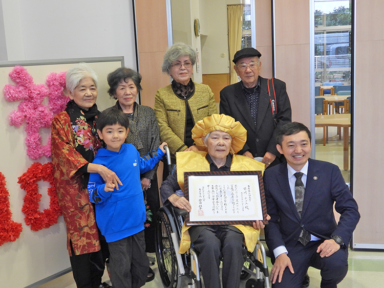 親戚に囲まれ100歳の誕生日を迎えた前﨑チヅエさん（8日、奄美市名瀬知名瀬の「なぎさ園」）