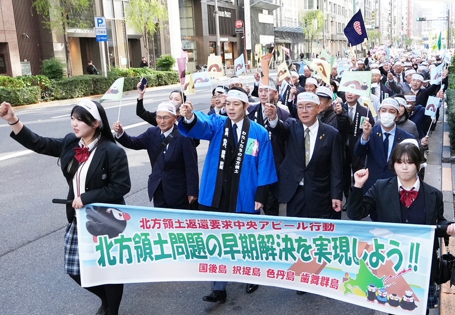 初参加の元島民4世の近藤さん（手前左）、荒井さん（同右）に続き、鈴木知事（中央）や石垣市長らが早期返還を訴えた（根室市提供）