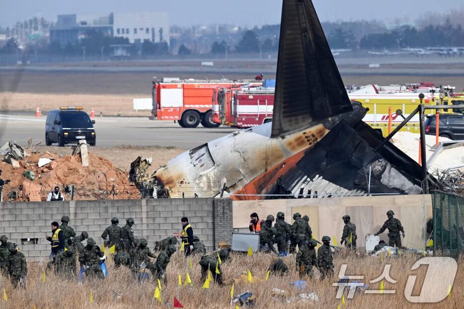 30日午前、務安国際空港で残骸を捜索する韓国軍関係者(c)news1