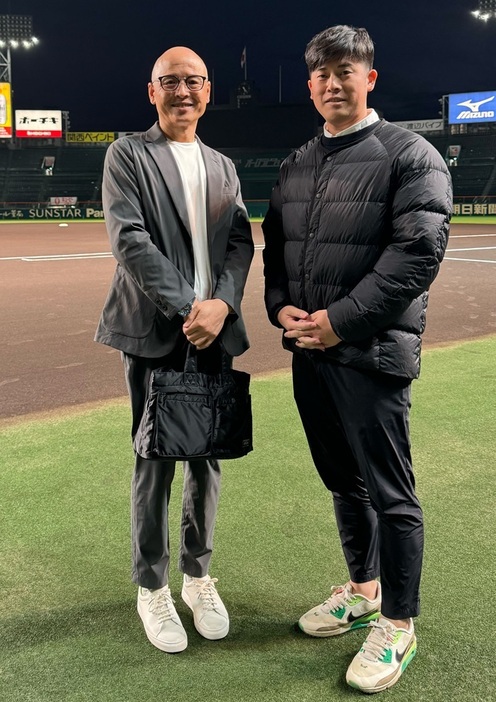 甲子園をバックにアジア甲子園を一緒につくってきたドラゴン桜の著者・三田紀房氏[左]と一緒に写真を撮る柴田章吾氏[右]