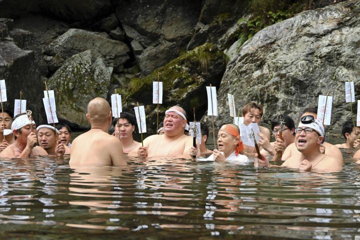 加茂川に漬かり、読経する参加者