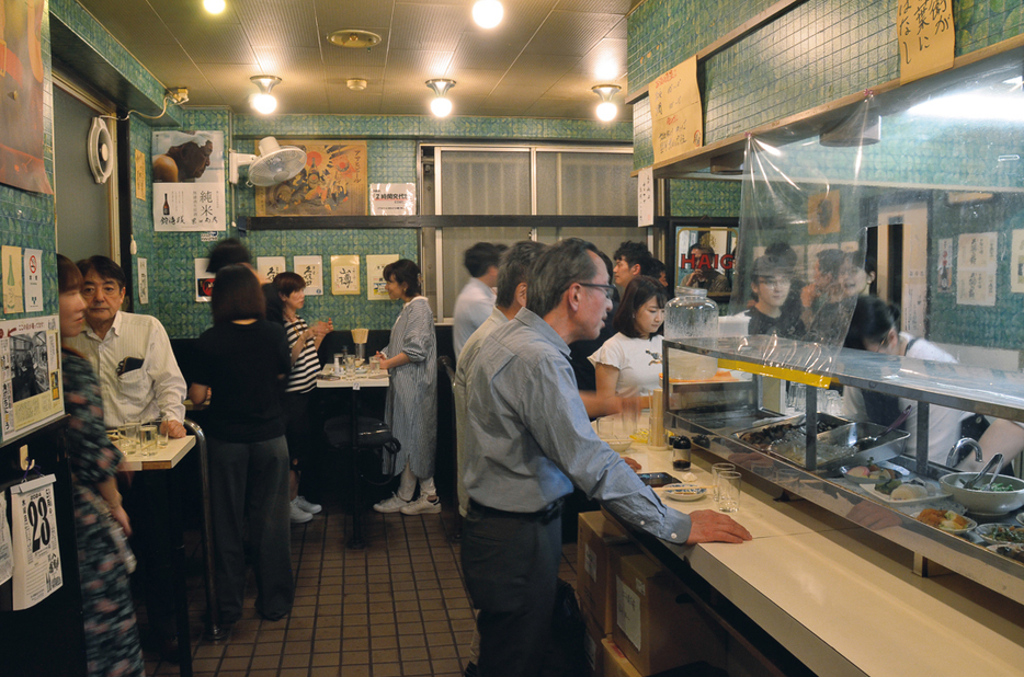 開店直後から多くの客でにぎわう。酒や料理、貼り紙にも注目。