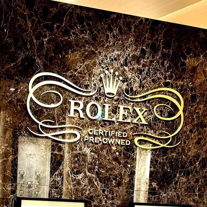 ロレックス ブティック 表参道の2階フロアにあるカウンター越し飾られた「ROLEX CERTIED PRE-OWNED」のロゴ（写真◎提供者撮影）