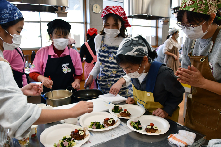 トナカイのハンバーグの飾りつけをする親子ら＝鴨川