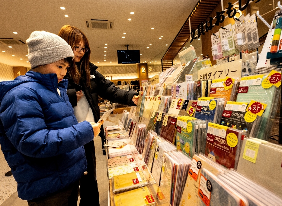 手帳を選ぶ買い物客＝11日、八戸市のアダチ類家店