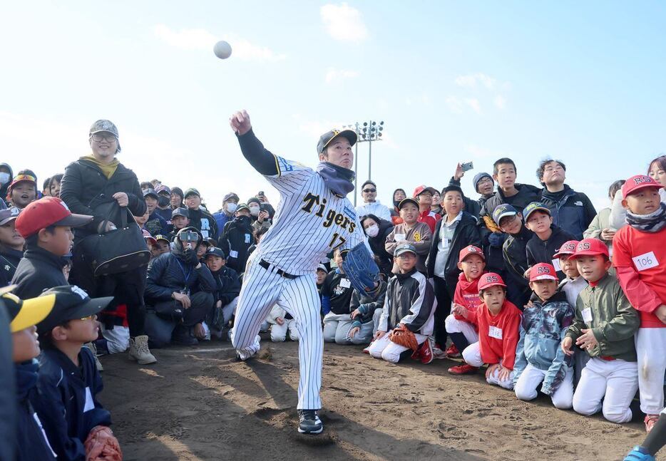 少年野球イベントにゲスト参加し、ユニホームでストラックアウトに挑戦する阪神・青柳晃洋＝小路明和グラウンド（撮影・中島信生）