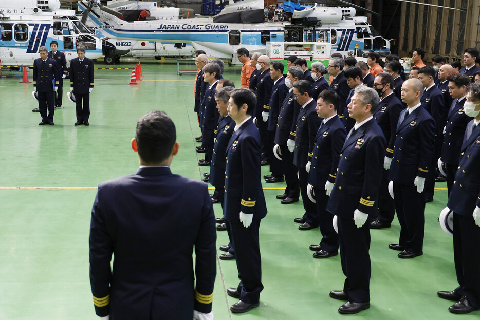 日本航空と海上保安庁の航空機が衝突炎上した事故から１年を前に、追悼式で黙とうする海保職員ら＝２３日午前、東京都大田区