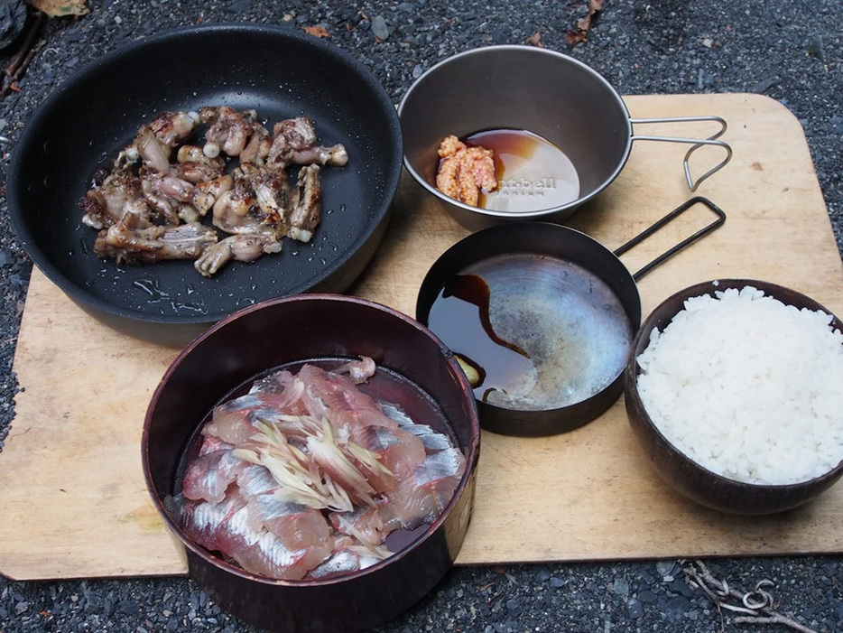 イワナの刺身とカエル炒めをおかずに夕食。獲物を美味しく食べるためにワサビと醤油など持参する調味料は増えていった。