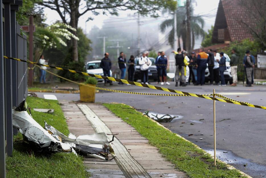 ブラジル南部の小型機墜落現場近くで、市街地に散らばった破片＝22日、リオグランデドスル州グラマド（ロイター＝共同）