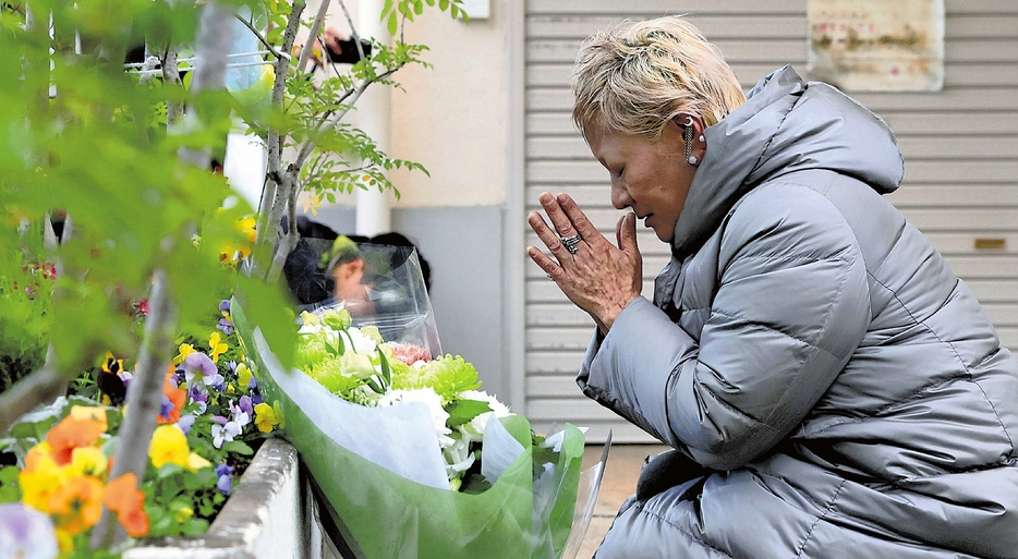 事件現場で献花し、手を合わせる遺族の大東真弓さん（19日午前7時12分、京都市山科区で）