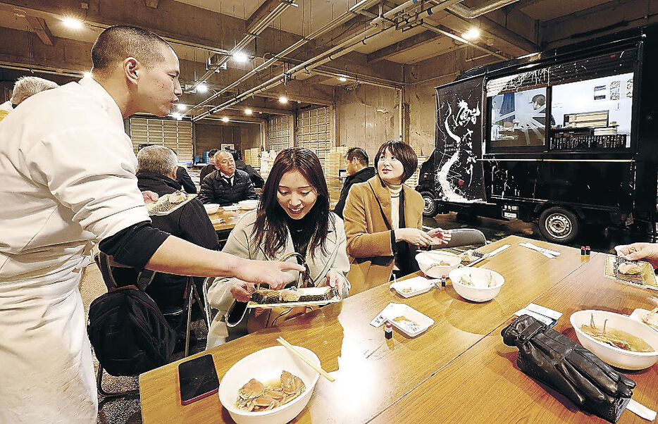 キッチンカーで握られたすしを味わう来場者　＝富山市の岩瀬漁港