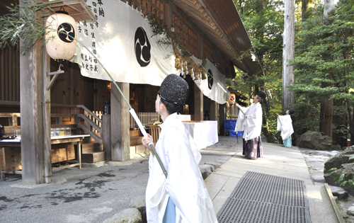 【笹竹ほうきですす払いをする神職ら＝鈴鹿市山本町の椿大神社外拝殿で】